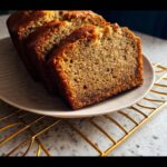 Close-up of three thick slices of moist Vegan Banana Bread Without Butter on a light plate.