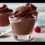 Close-up of a glass filled with rich, dark Vegan Chocolate Mousse, topped with a large, textured scoop.